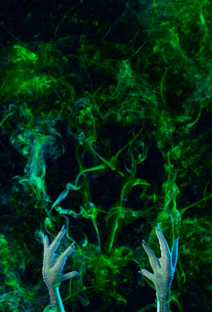Conceptual photo of pentagram, made of smoke and hands of a necromancer trying to call the devil. Halloween or religious concept.の写真素材