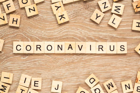 The word "Coronavirus" spelt out with letter tiles on the wooden backgroundの写真素材