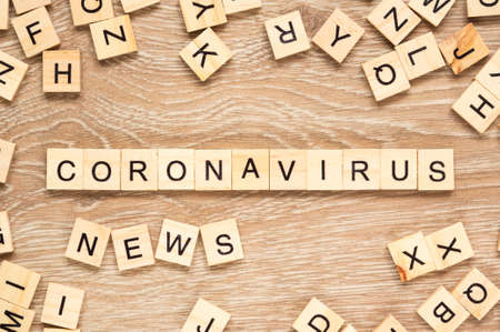 The words "Coronavirus News" spelt out with letter tiles on the wooden backgroundの写真素材