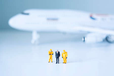 Group of toy scientists isolate a plane and its passengers. Quarantine or toxic person isolation concept.の写真素材