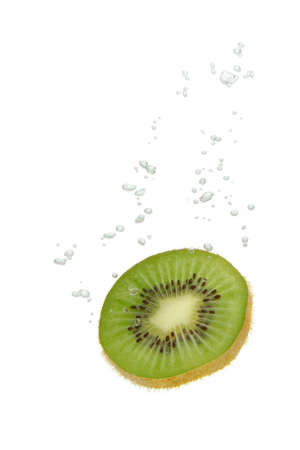 Kiwi fruit falling into water, with air bubbles, in front of white background, union of the three things essential to live which is air, water and nutritionの写真素材