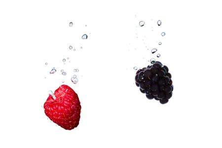 Raspberry and blackberry in water with air bubblesの写真素材
