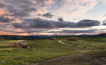 Huts in landscape of Norway during sunsetの写真素材