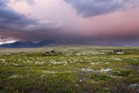 Huts in landscape of Norway during sunsetの写真素材