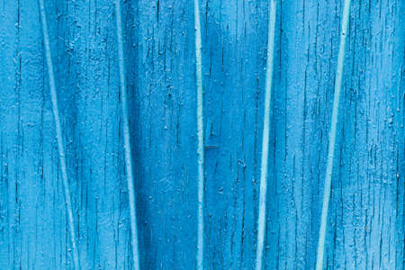 Texture exfoliating cracked blue paint. Vintage wooden background with vertical iron bars, with blue paint. Copy space concept.の写真素材