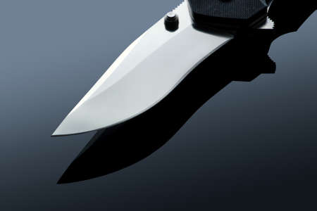 Battle metal folding knife on the background gradientの写真素材