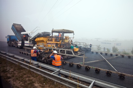 German workers repairing the road in spite of bad weather and fog