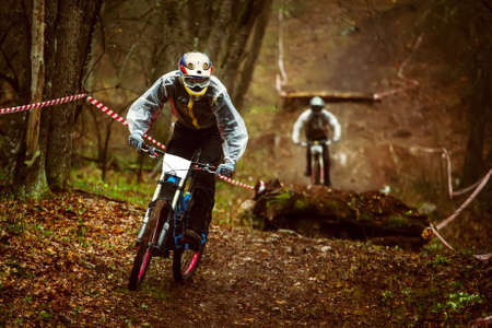 Two riders on mountain bike in the woods in bad weather