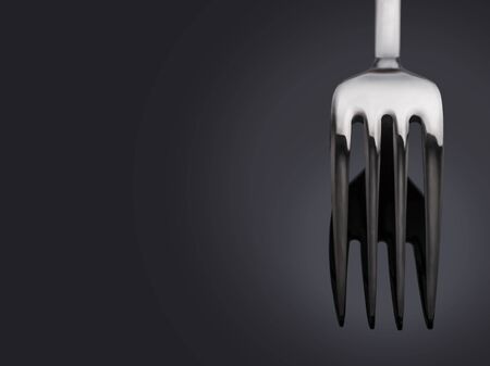 Fork on a dark background with space for text