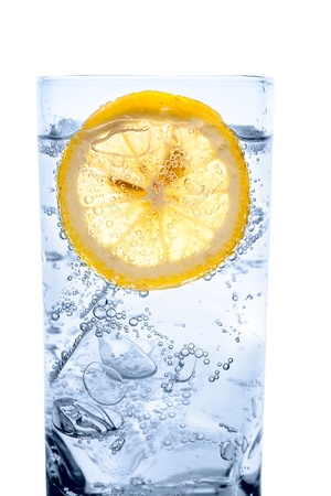 glass of fresh cool transparent water with ice and lemonの写真素材