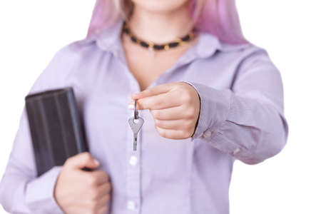 woman in a shirt with a tablet holds out the keys isolated on white backgroundの写真素材