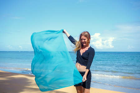 Young beautiful girl with blue pareo on tropical beachの写真素材