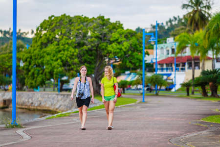 girls walking in the beautiful park among palm trees in Samana, Dominican Republicの写真素材