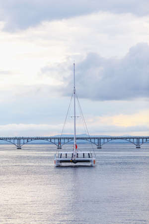 catamaran sailing in the sea on the background of the bridgeの写真素材