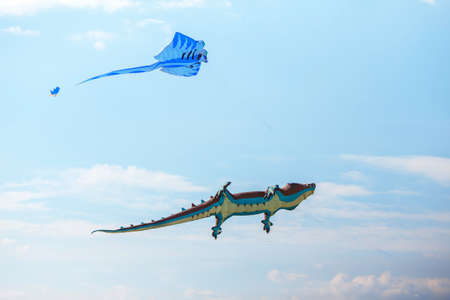 air crocodile kite and blue kite flying high in the sky. Kite festival. Family holiday. Kite competitionの写真素材