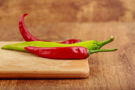 group of spicy red and green peppers on wooden Board