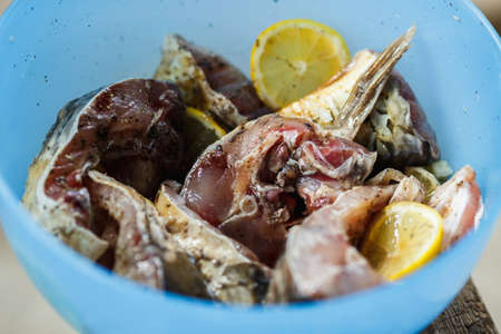 raw pieces of fish carp marinated with lemon in a blue bowlの写真素材