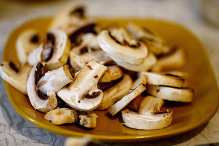 group of thin sliced champignons on a yellow plate. cuted mushroomsの写真素材