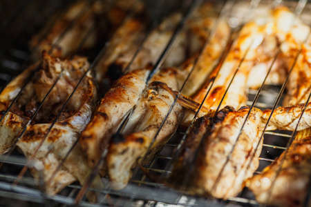 pieces of fish in the lattice frying on the grill close-up. Weekend bbqの写真素材