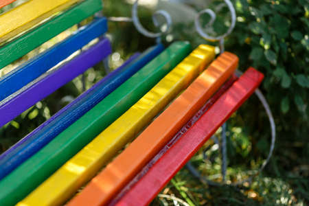 wooden  rainbow bench in the park close-up