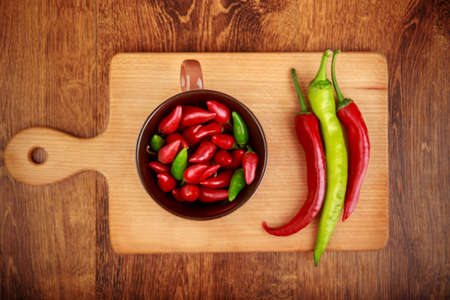 red and green chile peppers on a wooden board. Food cook concept