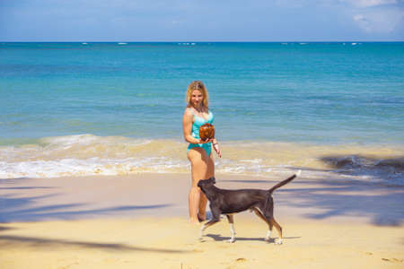 Young girl holding coconut on the beach and the dof runningの写真素材