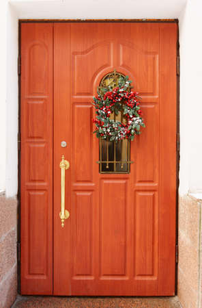 brown wooden door with a Christmas wreath. Christmas external decorationの写真素材