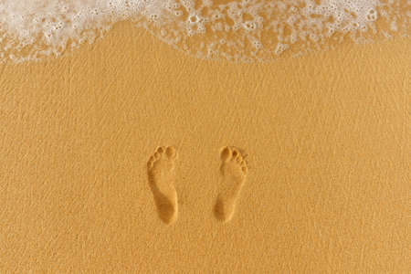 foot prints in the sand and sea surf. Vacation conceptの写真素材