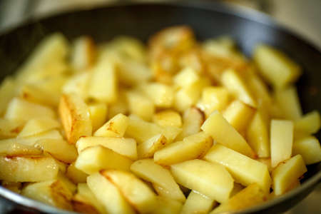 cooking of French fries or fried potatoes in a frying pan close upの写真素材