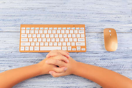 top view on female hands near wireless gold keyboard and mouse on grey wooden backgroundの写真素材