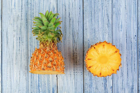 two halves of pineapple, cuteed ripe pineapple on light wooden backgroundの写真素材