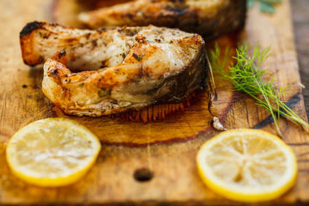 yammy grilled fish pieces with parsley on the wooden boardの写真素材