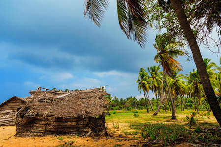 Thatched coconut leaf house or fishing hut on tropical beach in rainy weather. traditional or vintage eco friendly home in a rural villageの写真素材