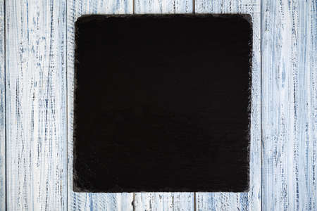black slate board on a wooden backgroundの写真素材