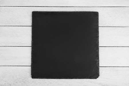 black slate board on a wooden backgroundの写真素材