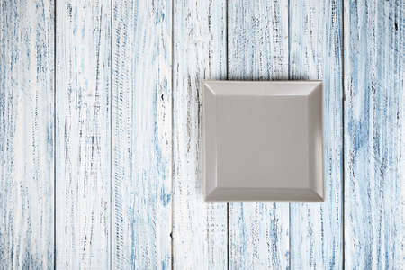 empty square plate on a wooden backgroundの写真素材