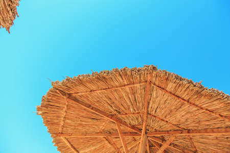 straw umbrella on blue sky background