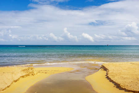 The river empties into the ocean on sandy beachの写真素材