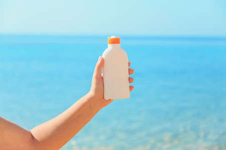 Female hands hold suntan lotion, skin sun protectionの写真素材