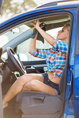young sexy woman washes the car, hot blonde girl  sitting in the car and wipes the dust in cabin