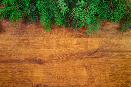 green spruce branches on wooden rustic background top view, layout