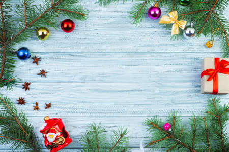 Christmas or new year frame flat lay, color wrapped presents, fir-tree branches and decorations on wooden background,top viewの写真素材
