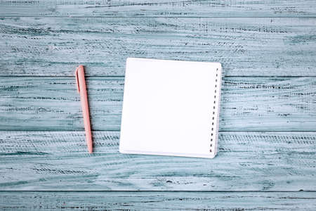 blank note book for list or text on wooden rustic background with pink penの写真素材