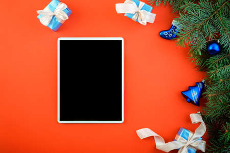 tablet with blank screen on new year or christmas red background with decorations, eccomers holiday conceptの写真素材