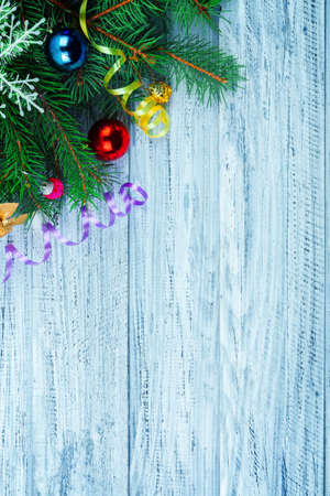 Christmas or new year flatlay design, fir-tree branch and holiday decorations on wooden background in left top corner,top viewの写真素材