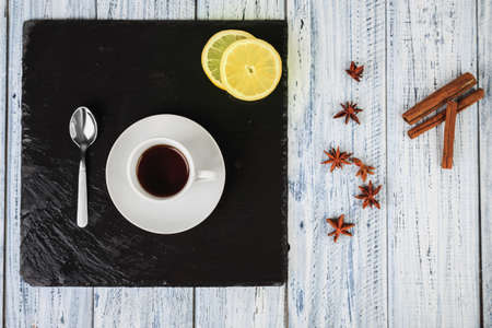 cup of hot coffe on black chalkboard, cinnamon sticks and star anise on rustic table, flat lay, top viewの写真素材