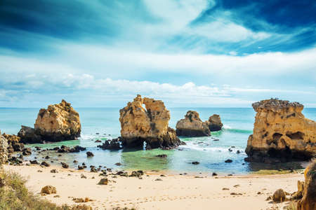 Rocks in blue ocean in sunny day, Algrave, Portugalの写真素材