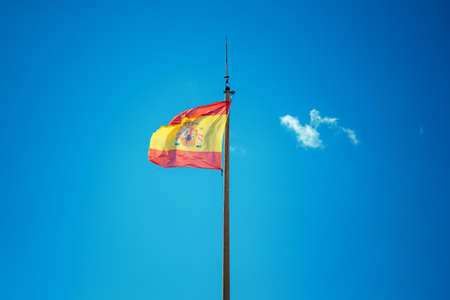spain flag on blue sky backgroundの写真素材