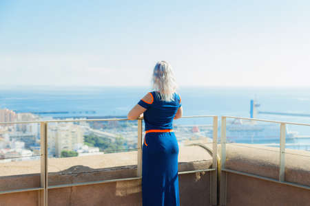 young woman admiring the view of the city from the observation pointの写真素材