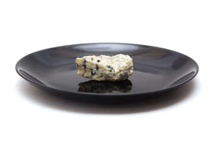 Piece of blue cheese with mold on black plateの写真素材